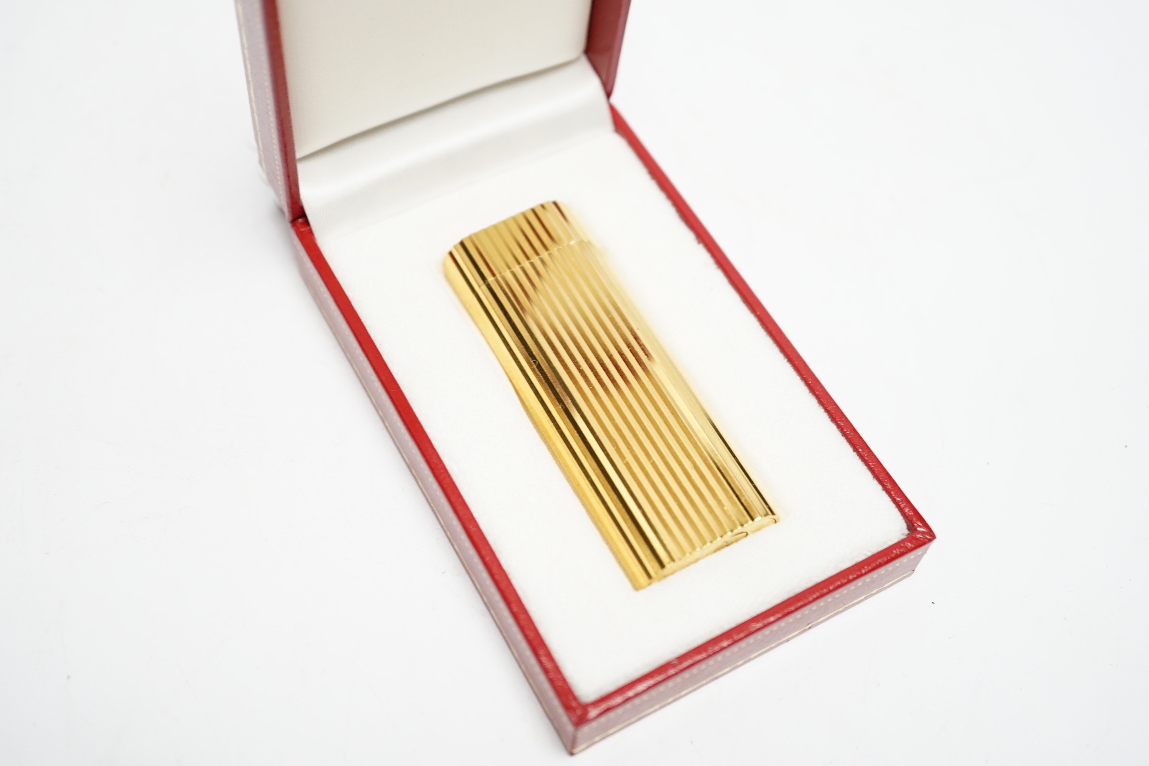 A Cartier gold plated lighter, with box and certificate.